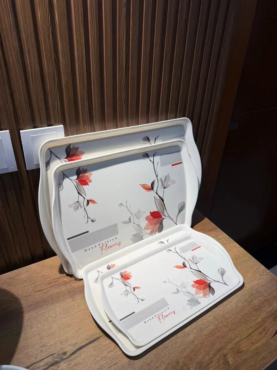 Takalluf hand-painted floral melamine trays, close-up of red and grey floral pattern